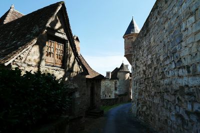 Street amidst houses against clear sky