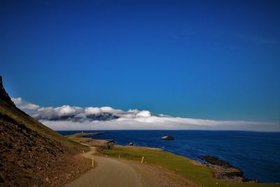 Scenic view of beach against cloudy sky