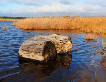 Rocks in lake against sky