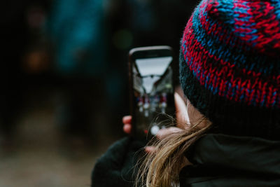 Rear view of mid adult woman using mobile phone during winter