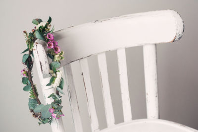 A minimalistic boho rustic bouquet of fresh flowers weighs on a white chair