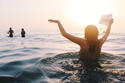 Woman on beach against sky during sunset