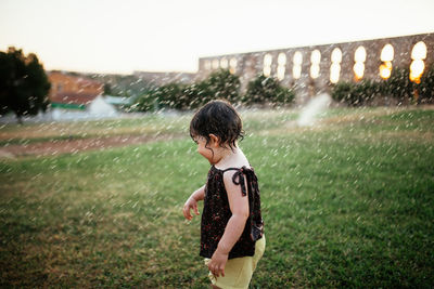 Full length of child playing with water sprinklers