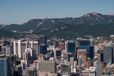 Aerial view of buildings in city against sky