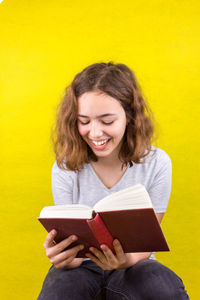 Smiling young woman holding book