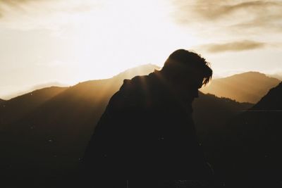 Silhouette man standing against sky during sunset