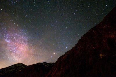 Low angle view of silhouette mountain against sky at night