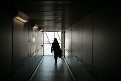 Rear view of man walking in corridor