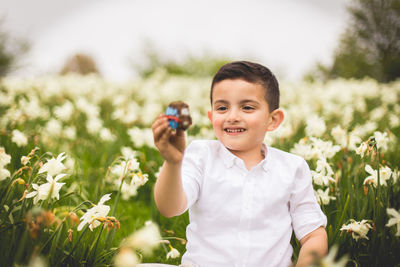 Portrait of cute boy holding a toy on field