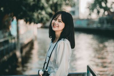 Portrait of smiling young woman standing outdoors