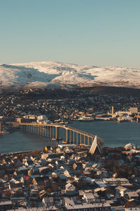 View of the polar town of tromso in northern norway and the snowy hills in the background at sunset. 