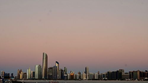 Modern buildings in city against sky during sunset in abu dhabi