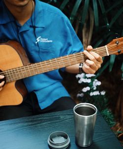 Midsection of man playing guitar