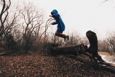 Side view of man jumping in forest