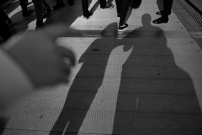 High angle view of people shadow on footpath