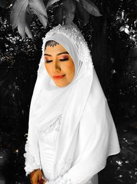 Close-up of woman wearing mask against trees