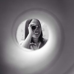 Woman holding paper roll seen through hole