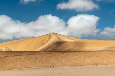 View of desert against cloudy sky