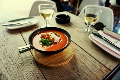 High angle view of soup with wine served on wooden table