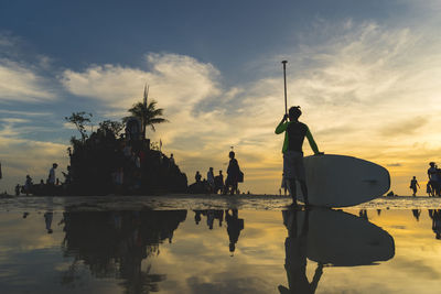 Reflection of statue on palm tree against sky