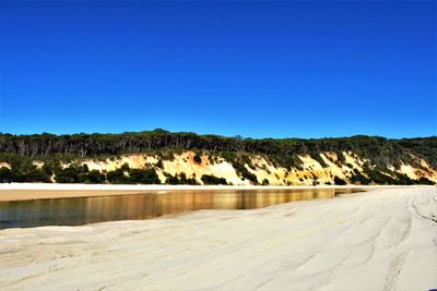 Scenic view of dam against clear blue sky