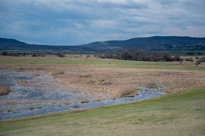 Scenic view of land and mountains against sky