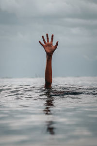 Person swimming in sea against sky