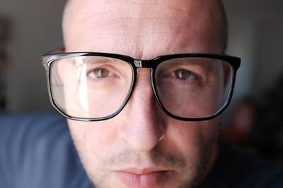 Close-up portrait of man wearing eyeglasses at home