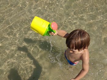 High angle view of boy holding toy at beach