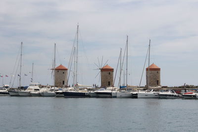 Sailboats moored on sea against sky