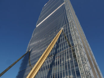 Low angle view of skyscraper against clear blue sky