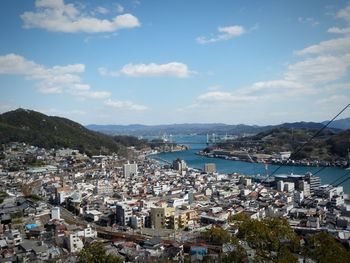 High angle view of townscape by sea against sky