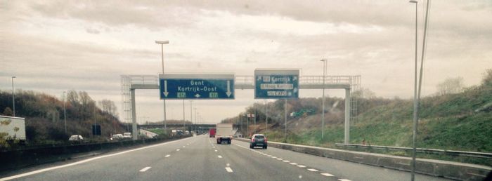 Road sign against sky