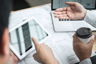 Midsection of man using laptop on table