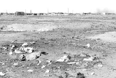 Garbage on field by road against sky