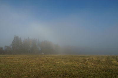 Scenic view of field against sky during foggy weather