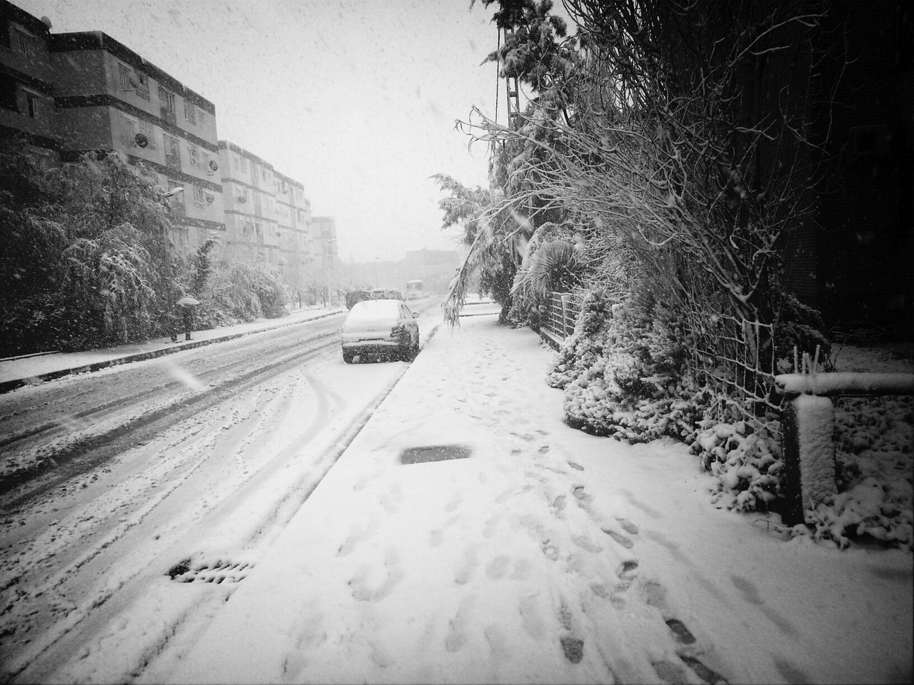 transportation, road, snow, car, street, building exterior, built structure, land vehicle, architecture, winter, the way forward, mode of transport, tree, cold temperature, season, weather, outdoors, no people, diminishing perspective, clear sky