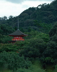 Scenic view of temple amidst trees and mountains against sky