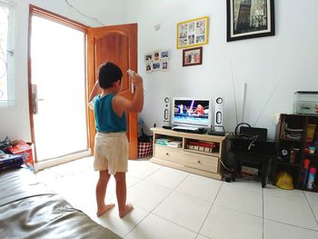 Rear view of boy standing at home