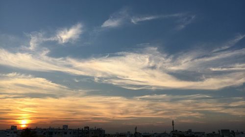 View of city against cloudy sky during sunset