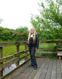 Woman standing on tree trunk