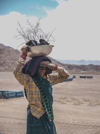 Rear view of person wearing hat standing on land