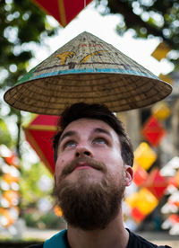 Close-up of asian style conical hat over man outdoors