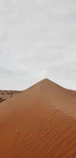 Sand dune in desert against sky