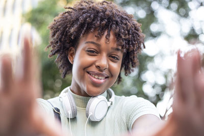 Portrait of an attractive dark-skinned curly-haired woman taking a selfie positive vibes 