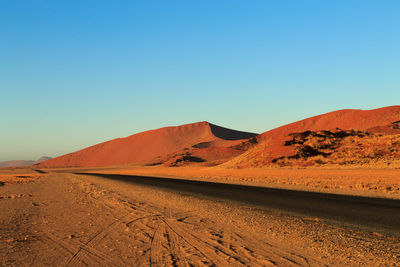 Scenic view of desert against clear blue sky