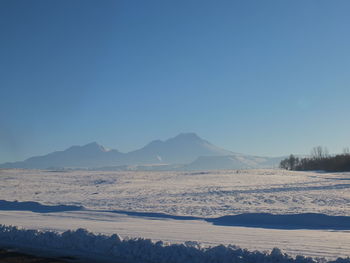 Scenic view of snowcapped mountains against clear blue sky