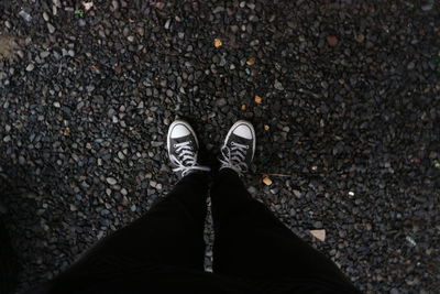 Low section of man standing on cobblestone street