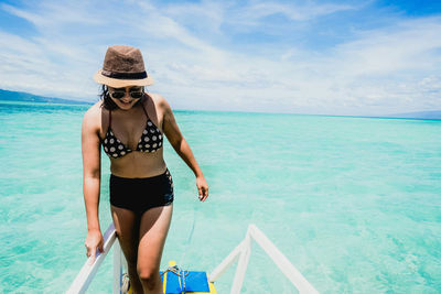 Woman standing on beach against sky