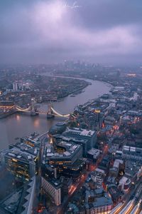 High angle view of illuminated city buildings by river